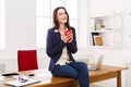 Business woman sitting on wooden desk at office Royalty Free Stock Photo