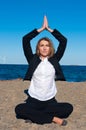 Business woman sitting in yoga pose on the beach Royalty Free Stock Photo