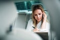 Business woman with smartphone sitting on back seats in taxi car. Royalty Free Stock Photo