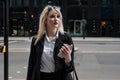 Business woman with a smartphone staning on the street