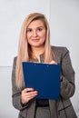 Business woman standing with clipping board in the office and ready to write something. Royalty Free Stock Photo