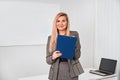Business woman standing with clipping board in the office and ready to write something. Royalty Free Stock Photo