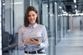 Business woman standing in hall and using digital tablet Royalty Free Stock Photo