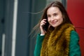 Business woman standing by modern office building, smiling and talking on the phone Royalty Free Stock Photo