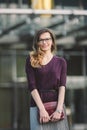 Business woman standing on street against office building. City business woman working. Portrait business woman smiling