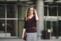 Business woman standing on street against office building. City business woman working. Portrait business woman smiling