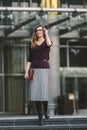 Business woman standing on street against office building. City business woman working. Portrait business woman smiling