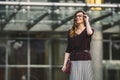 Business woman standing on street against office building. City business woman working. Portrait business woman smiling