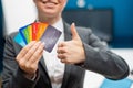 Business woman in a suit holds a lot of different credit cards and shows a thumb up. Royalty Free Stock Photo
