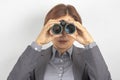 Business woman in suit looking through binoculars