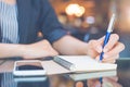 Business woman is taking notes on a note pad with a pen in the o Royalty Free Stock Photo