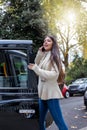 Business woman talking on her mobile phone whilst steps into a black taxi Royalty Free Stock Photo