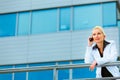 Business woman talking mobile near office building Royalty Free Stock Photo