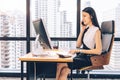 Business Woman talking with mobile phone on her desk in Modern office building Royalty Free Stock Photo