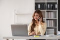 Business woman talking on a phone call in office. Happy female professional calling her associates on a mobile phone Royalty Free Stock Photo