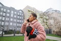 Business woman talking on the phone and walking the dog holding in her hands. Portrait of woman communicates on smartphone with Royalty Free Stock Photo