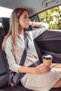 Business woman taxi car, summer city, resting after work and looking out window, holding cup coffee tea, having snack Royalty Free Stock Photo