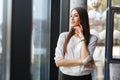 Business woman thinking, standinding near the window in the restaurant Royalty Free Stock Photo