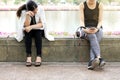 Business woman tired form hard working sitting near the relaxing sport woman in city park