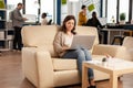 Business woman typing on laptop sitting on couch Royalty Free Stock Photo