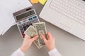 Business woman using calculator and holding money. Royalty Free Stock Photo