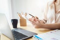 Business woman using calculator to review balance sheet annual with holding pen and using laptop computer to calculating Royalty Free Stock Photo