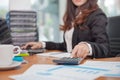 Business woman using calculator and writing make note with calculate