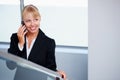 Business woman using cell phone. Young business woman listening to call on cellphone.