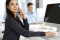 Business woman using computer at workplace in modern office. Brunette secretary or female lawyer smiling and looks happy Royalty Free Stock Photo