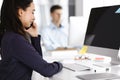 Business woman using computer at workplace in modern office. Brunette secretary or female lawyer smiling and looks happy Royalty Free Stock Photo