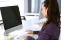 Business woman using computer at workplace in modern office. Brunette secretary or female lawyer smiling and looks happy Royalty Free Stock Photo