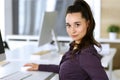 Business woman using computer at workplace in modern office. Brunette secretary or female lawyer smiling and looks happy Royalty Free Stock Photo