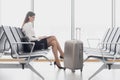 Business woman using laptop at the airport sitting at the window Royalty Free Stock Photo