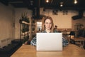 Business woman using laptop at cafe. Young beautiful girl sitting in a coffee shop and working on computer Royalty Free Stock Photo