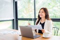 Business woman using laptop on wooden desk sitting in stylish office or cafe with bright smile and positive attitude Creativity. Royalty Free Stock Photo