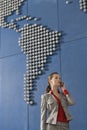 Business woman using mobile phone in front of world map in office Royalty Free Stock Photo