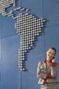 Business woman using mobile phone in front of world map in office Royalty Free Stock Photo