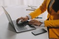 Business woman using mobile phone during working on laptop computer, surfing the internet, searching business data at modern Royalty Free Stock Photo