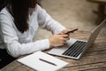 Business woman using smartphone after working with laptop on table, businesswoman using mobile phone to search or social media or Royalty Free Stock Photo