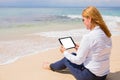 Business woman using tablet on the beach Royalty Free Stock Photo