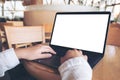 Business woman using and typing on laptop with blank white desktop screen in cafe Royalty Free Stock Photo