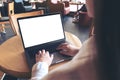 Business woman using and typing on laptop with blank white desktop screen in cafe Royalty Free Stock Photo