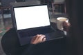 Business woman using and typing on laptop with blank white screen while drinking coffee in cafe Royalty Free Stock Photo