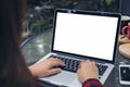 Business woman using and typing on laptop with blank white screen , smart phone and coffee cups on glass table Royalty Free Stock Photo