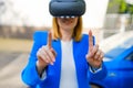 Business woman using VR goggles touching the simulation screen in the park