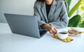 A business woman using and working on laptop computer while drinking coffee in office Royalty Free Stock Photo