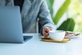 A business woman using and working on laptop computer while drinking coffee in office Royalty Free Stock Photo