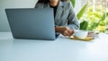 A business woman using and working on laptop computer while drinking coffee in office Royalty Free Stock Photo