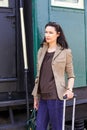 Business woman on vacation at the railway station near the passenger railcar