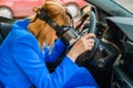 Business woman in the VR googles sitting in the car and put her head on the steering wheel.